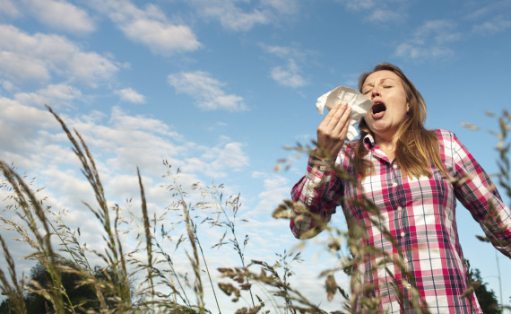 Woman sneezing in tall grass