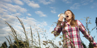 Woman sneezing in tall grass